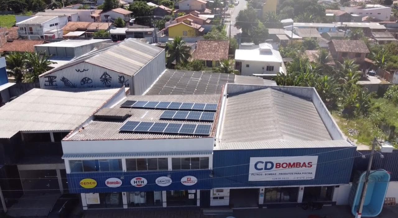 Loja com painéis solares instalados no telhado, em avenida movimentada