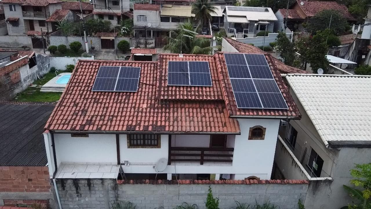 Casa com telhado de telhas e três conjuntos de painéis solares instalados