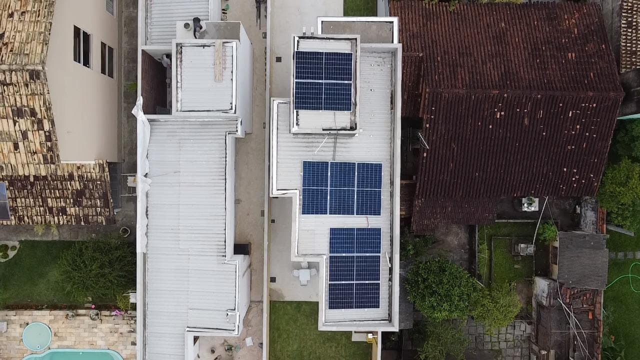 Painéis solares instalados no telhado de um prédio em área urbana